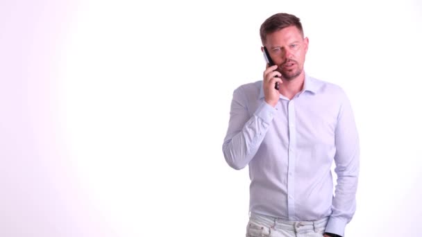 Podnikatel mluví na chytrém telefonu s potenciálním klientem pro obchodní projekt v kanceláři společnosti. Podnikatel vysvětluje smluvní ujednání detaily na telefonu - Záběry, video
