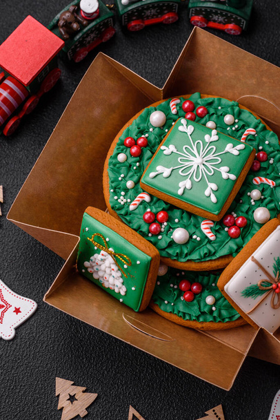 Bellissimo pan di zenzero natalizio festivo realizzato a mano con elementi decorativi su uno sfondo di cemento scuro - Foto, immagini