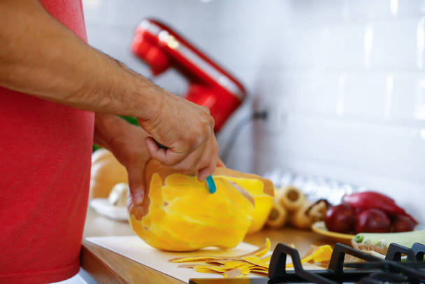 Mann reicht Lebensmittel aus nächster Nähe: Gemüse in der Küche kochen - Foto, Bild