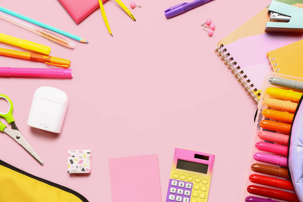 Marco hecho de calculadora y diferentes artículos de papelería sobre fondo rosa - Foto, Imagen