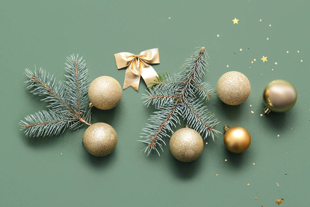 Χριστουγεννιάτικο δέντρο κλαδιά με μπάλες και τόξο σε πράσινο φόντο - Φωτογραφία, εικόνα