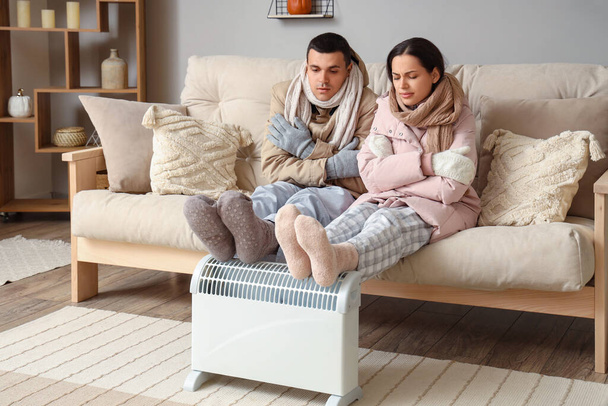 Jovem casal aquecimento pernas no radiador em casa - Foto, Imagem