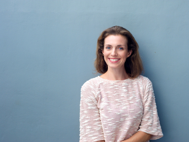Mulher adulta média bonita sorrindo no fundo cinza
 - Foto, Imagem