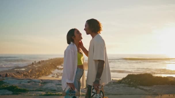 Romantic lovers kissing on sunrise beach. Sensual skaters couple bonding each other looking sea horizon. Smiling boyfriend and girlfriend enjoying leisure time at ocean shore. Tenderness concept - Footage, Video