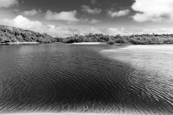 Paisagem em preto e branco de um rio com céu e nuvens no fundo. Valenca, Brasil - Foto, Imagem