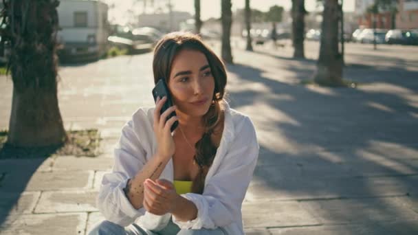 Positive Mädchen telefonieren bei sonnigem Tag außen aus nächster Nähe. Millennial Lady, die mit ihrem Smartphone auf Witze im Freien reagiert. Lächelnde Hipster-Frau erzählt lustige Geschichte bei Handy-Chat zeigt Emotionen  - Filmmaterial, Video