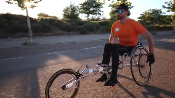 mężczyzna na wózku inwalidzkim trening na świeżym powietrzu z wózkiem wyścigowym - Materiał filmowy, wideo