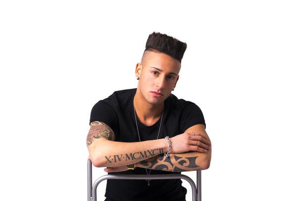 Tattooed young man sitting on chair backwards - Foto, Imagem