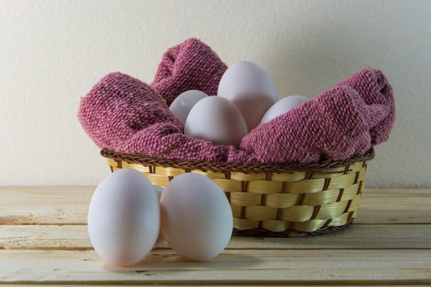 赤い皿タオルで編まれたバスケットに新鮮な卵。選択的な婦人 - 写真・画像