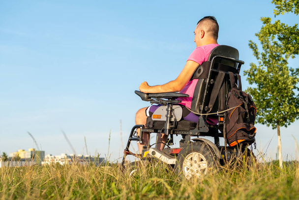 Un hombre discapacitado sentado en una silla de ruedas y se muda a casa - Foto, imagen
