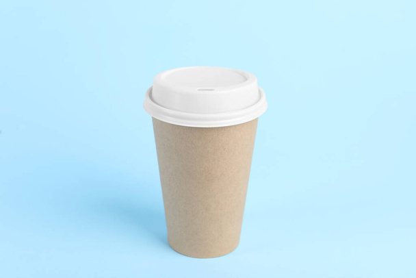 Paper cup with plastic lid on light blue background. Coffee to go - Photo, image
