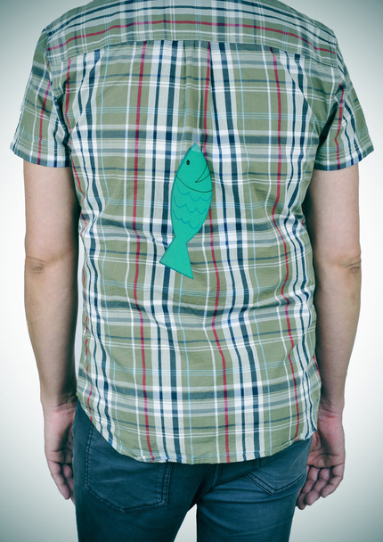 jonge man met een papieren vis aangesloten op zijn rug - Foto, afbeelding