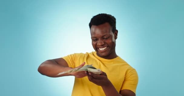 Happy black man, money and winning cash in finance celebration, savings or investment against a studio background. African male person smile with dollar bills, paper or notes in financial freedom. - Footage, Video