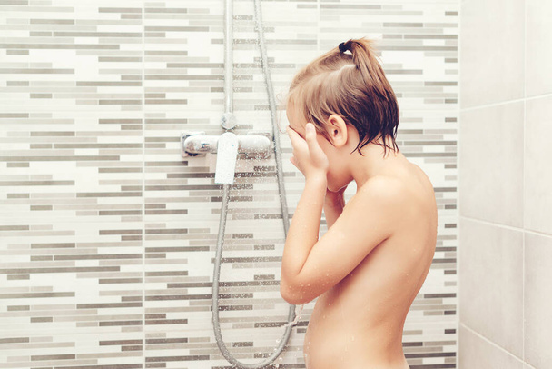 Cute child washing himself in shower. Happy boy having a shower in bathroom. Healthy childhood, lifestyle concept. - Photo, Image