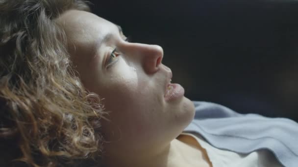 Close-up retrato de jovem mulher caucasiana apática com cabelo encaracolado deitado no sofá falando sobre sua depressão - Filmagem, Vídeo