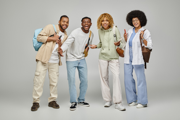 joyeux amis afro-américains gesticulant et regardant joyeusement la caméra, style de vie étudiant - Photo, image