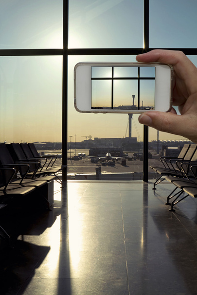 Камера мобильного телефона делает фото зала вылета современный аэропорт
 - Фото, изображение