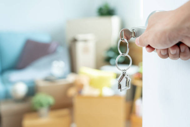 Moving house, relocation. Man hold key house keychain in new apartment. move in new home. Buy or rent real estate. flat tenancy, leasehold property, new landlord, investment, dwelling, loan, mortgage - Foto, Imagen
