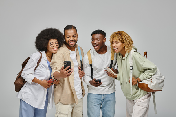 joven hombre guapo mostrando a sus amigos algo alegre en su teléfono, estilo de vida estudiantil - Foto, imagen
