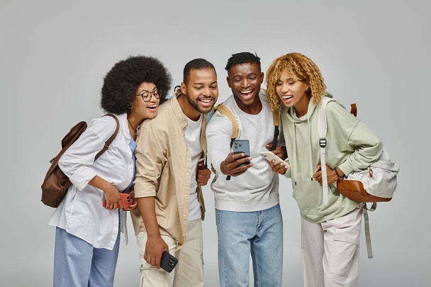 young stylish man with his friends laughing at something on mobile phone, student lifestyle - Photo, Image