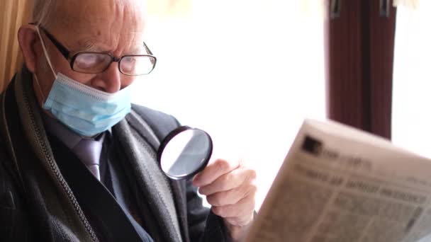 Retrato de un anciano abuelo caucásico leyendo un periódico mientras estaba sentado en una cafetería. Prensa fresca - Imágenes, Vídeo