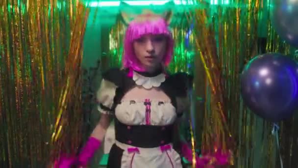 Medium portrait of self-confident Caucasian girl cosplaying cat maid anime character opening golden foil fringe curtains and posing on camera - Footage, Video