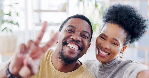 African couple, selfie and home with peace sign, smile or romance on blog, love or bonding with emoji. Black woman, man and photography for portrait, profile picture and icon on social media in house. - Photo, Image