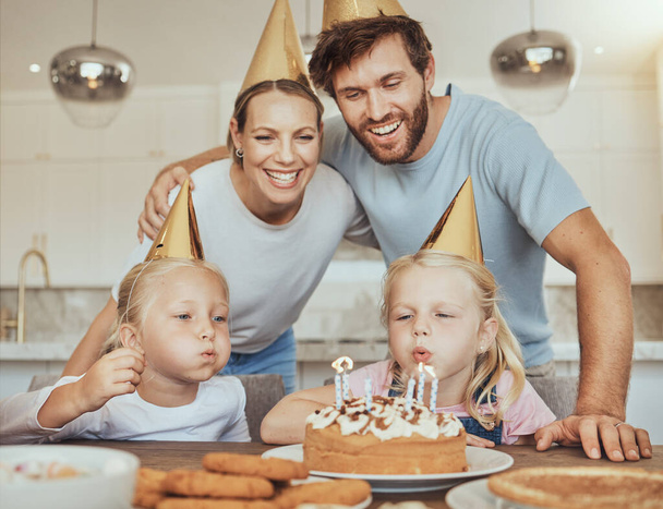 Szülők, gyerekek és gyertyafújás szülinapi tortán ünneplés mosollyal, szeretettel és édességgel otthon. Boldogság, család és anya, apa és gyerekek együtt az asztalnál a lány party esemény a házban - Fotó, kép
