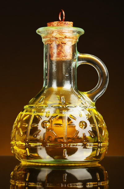Jar with olive oil on a yellow background - Zdjęcie, obraz
