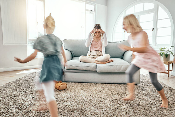 Mutter, Kinder und Laufen im Wohnzimmerchaos mit Kopfschmerzen im Stress auf dem Sofa zu Hause. Frustrierte Alleinerziehende im Burnout mit ADHS oder hyperaktiven Kindern oder Geschwistern, die im Haus spielen. - Foto, Bild
