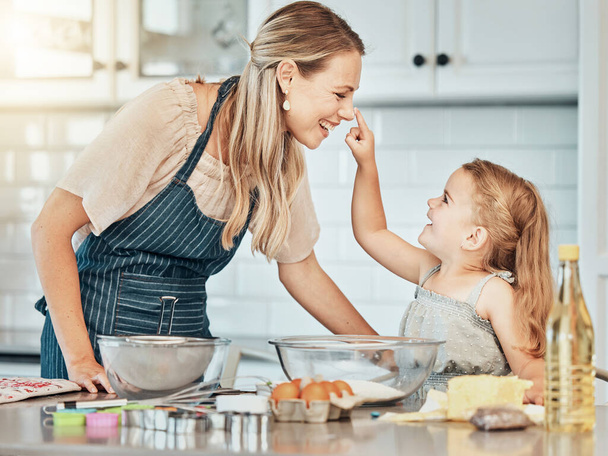 Happy mother in kitchen, bake together with child and flour, playing and learning with woman. Love, mom and girl kid with help baking cookies in home with care, support and teaching at playful lunch - Photo, Image