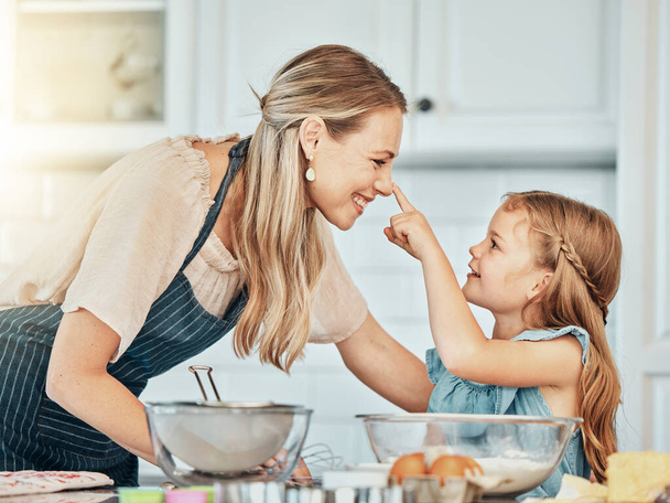 Παιχνιδιάρα μαμά στην κουζίνα, ψήσιμο μαζί με παιδί και χαρούμενη μάθηση, διατροφή και πρωινό με γυναίκα. Χαμογελάστε, μητέρα και κορίτσι, μαγειρεύοντας ή παίζοντας στο σπίτι με φροντίδα, υποστήριξη ή αγάπη στο πρωινό. - Φωτογραφία, εικόνα