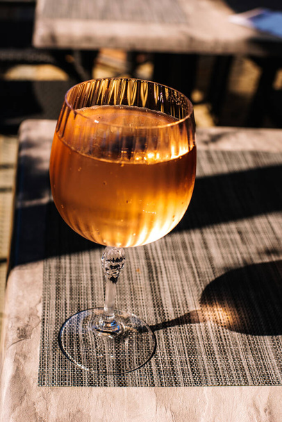 Ποτήρι κρασιού γεμάτο με αφρώδη ροζέ οίνο. - Φωτογραφία, εικόνα