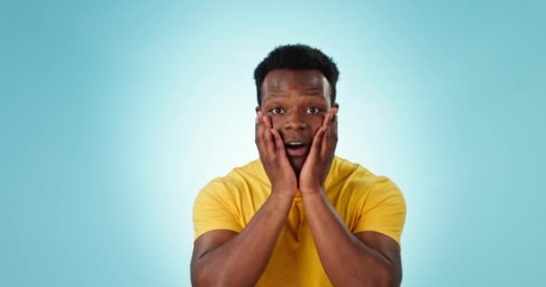 Surprise, face and black man celebrate, excited or happy for success news, studio announcement or achievement. Victory, OMG portrait and winner cheers, applause or shocked reaction on blue background. - Filmagem, Vídeo