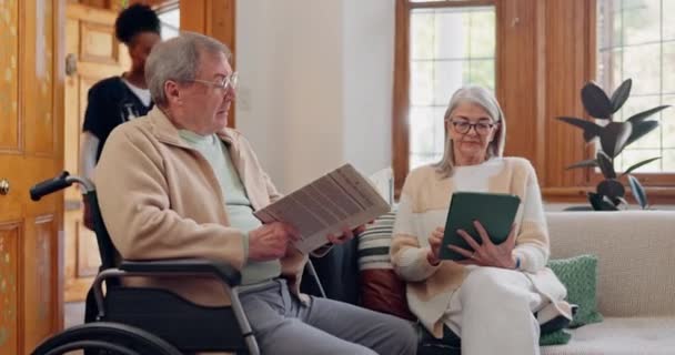 Oudere zorg, verpleegkundige en thuis praten met mensen die boeken, nieuws of tabletten lezen met discussie over ondersteuning. Pensioen, verzorger en ontspannen in gesprek of huiskamer met notebook. - Video