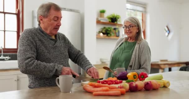 Old couple in kitchen, cooking together with discussion and help, support or planning recipe with vegetable. Healthy food, senior man and woman in home with conversation for meal prep, diet and lunch. - Footage, Video