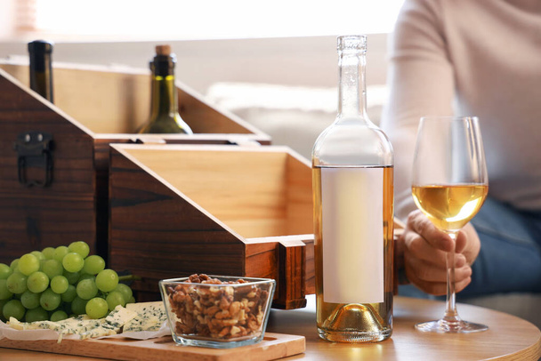 自宅でテーブルの上にワインと軽食を持つ若い男, クローズアップ - 写真・画像