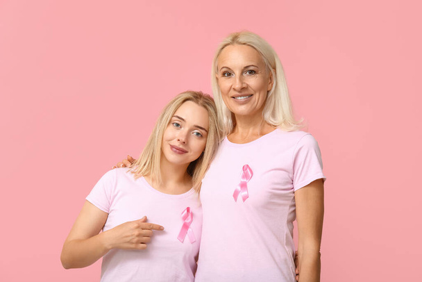 Women with ribbons on pink background. Breast cancer awareness concept - Photo, Image