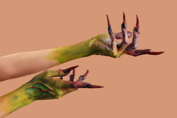 ベージュの背景に爪を持つ魔女の手. ハロウィーンのお祝い - 写真・画像