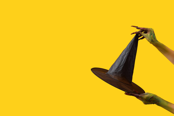 Czarownica z kapeluszem na żółtym tle. Święto Halloween - Zdjęcie, obraz