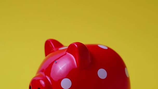 man puts money in a piggy bank on a yellow background - Footage, Video