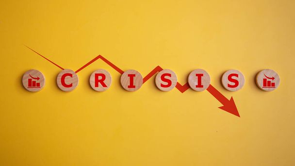 Dřevěné kostky se slovem krize a červenou šipkou dolů na žlutém pozadí, obchodní finanční ztráta, koncepce krize. - Fotografie, Obrázek