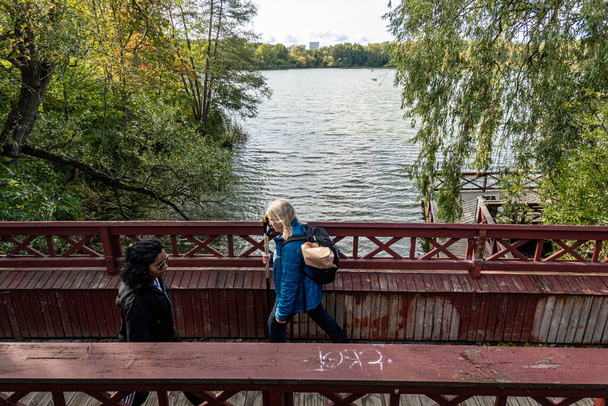 Estocolmo, Suecia Oct 4, 2023 Los peatones caminan sobre un pequeño puente en el suburbio de Bromma, cerca del lago Ulvsunda. - Foto, imagen