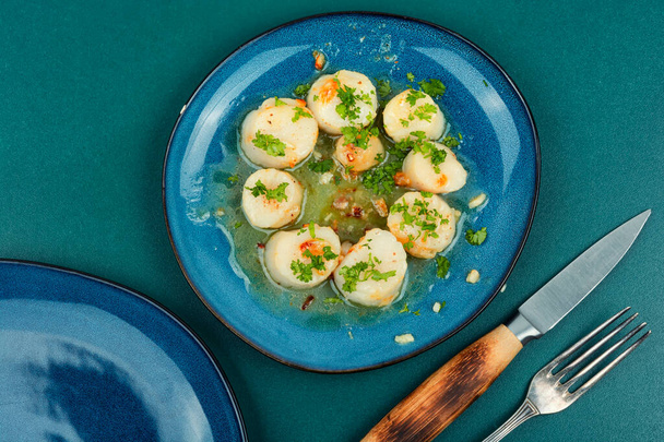 pétoncles frits avec du vert dans une assiette, fruits de mer. Vue du dessus. - Photo, image