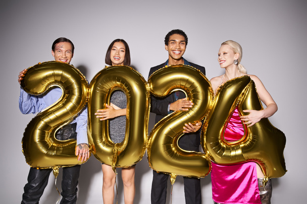 grupo de amigos multiétnicos felices sosteniendo globos con 2024 números durante la fiesta, concepto de Año Nuevo - Foto, imagen