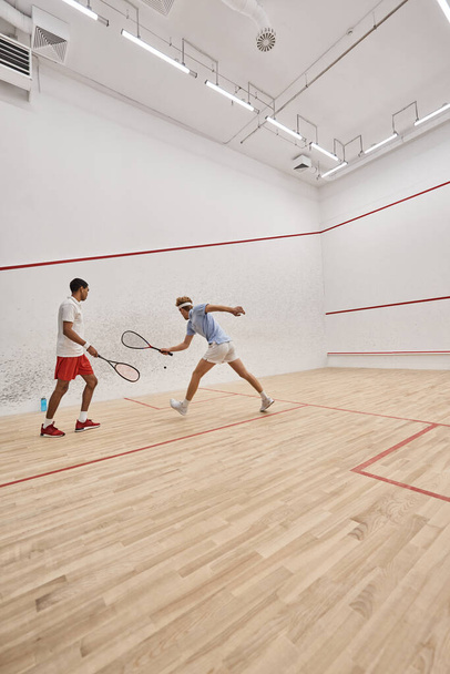 interracial athletic men in sportswear playing together inside of squash court, motivation - 写真・画像