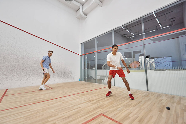 young multiethnic players in sportswear playing squash inside of court, effort and motivation - Photo, image