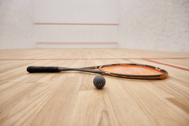piłka i rakieta na podłodze wewnątrz krytego kortu do squasha, koncepcja motywacji i determinacji - Zdjęcie, obraz