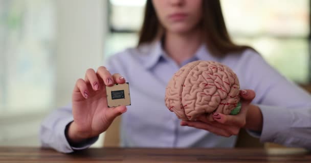 Person holds tiny computer chip in plastic model of human brain. Artificial intelligence in education - Footage, Video