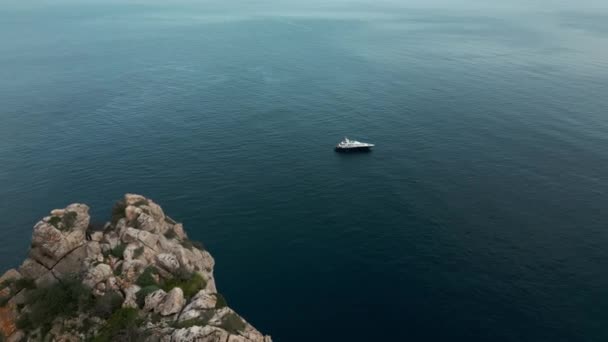 Vue aérienne du yacht flottant contre les rochers Es Verda. Un grand yacht flottant seul dans la mer bleue. Images 4k de haute qualité - Séquence, vidéo